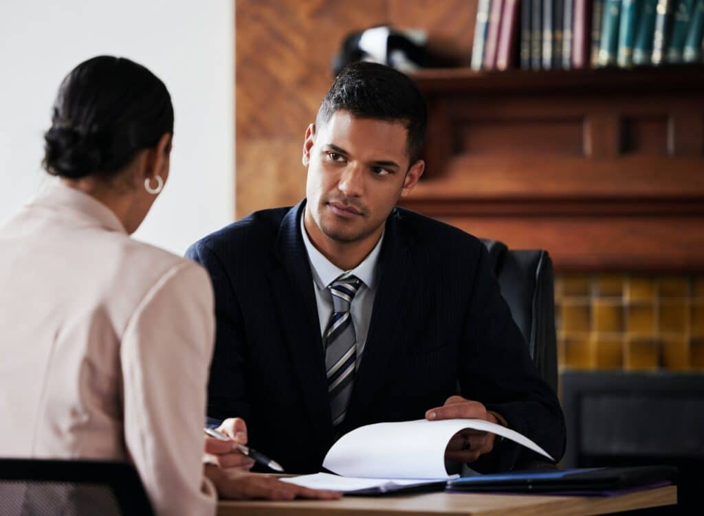Contrato, firma y abogado que consulta a un cliente en su oficina con trámites legales o acuerdos